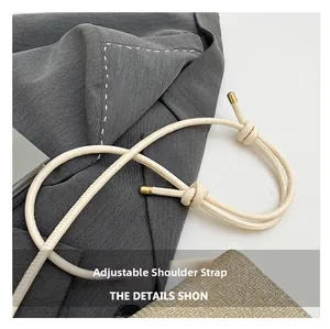 Détail de la bandoulière réglable beige avec embouts métalliques dorés sur un sac chic