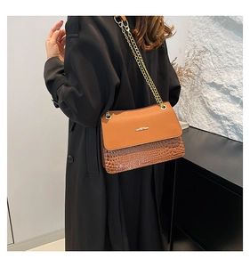 Detail of vintage brown textured leather shoulder bag with golden chain and metal buckle