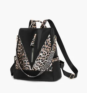 Detail of fashion leopard print backpack featuring front vertical tassel zipper and side pockets