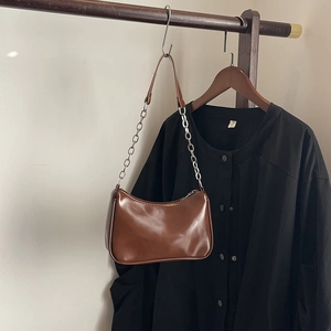Detail of coffee brown glossy faux leather shoulder bag with adjustable metal chain strap