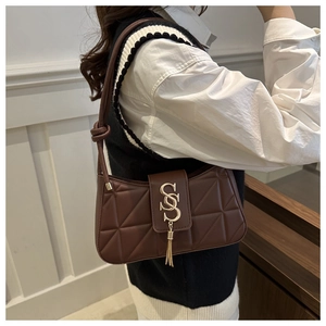 Macro detail of the dark brown quilted shoulder bag with golden SS logo and fringe