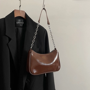 Detailed view of brown glossy PU leather underarm bag with metal chain strap