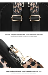 Detail of adjustable metal buckle and detachable leopard strap on black backpack
