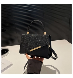 Detail of black PU leather shoulder bag with sequined flap and gold metal trim detail