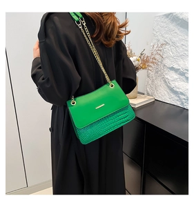 Detail of green PU leather shoulder bag with gold chain and crocodile texture panels