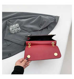 Detail view of the red leather shoulder bag open interior with gold magnetic snap button