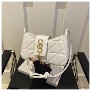 Detail of white quilted handbag featuring gold serpent hardware and elegant tassel detail