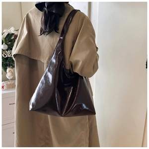 Deep brown glossy Hobo bag styled with a khaki trench coat for a winter commute look