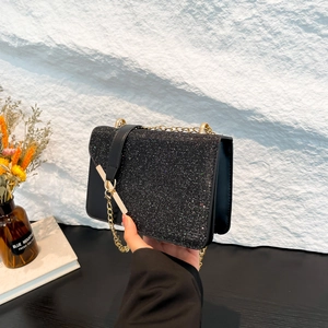 Chic black glitter crossbody chain bag with gold hardware for elegant winter occasions