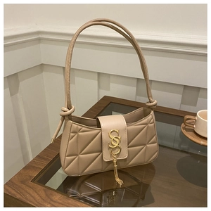 Detail of triangle quilted faux leather bag with gold hardware and tassel charm