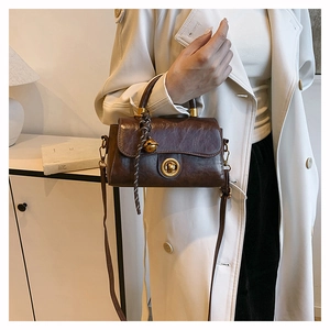 Detailed shot of a vintage brown bag with oil-wax texture and golden ring handle