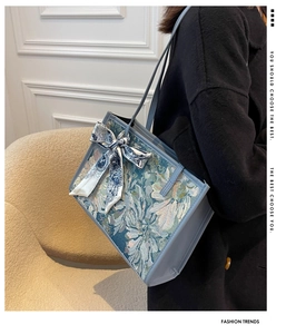 Détail du sac cabas en jacquard bleu sarcelle avec motif floral vintage et nœud en soie
