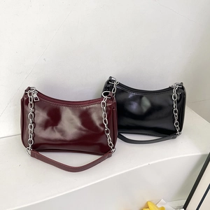 Glossy leather underarm bags in black and burgundy with silver chain straps in detail