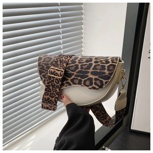 Detail of saddle bag featuring leopard print wide strap and gold hardware accents