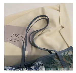 Détails du tissu jacquard bleu et des fines bretelles en cuir du sac cabas