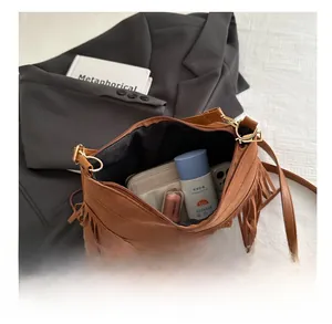 Brown suede tassel crossbody bag showing spacious interior for daily essentials storage