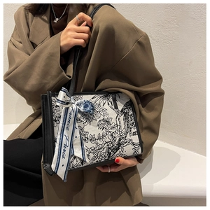 Détail du cabas en toile florale avec poignée en cuir noir et foulard en soie Paris