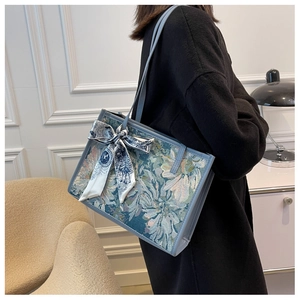 Détail du sac cabas jacquard bleu vintage avec un foulard décoratif en soie élégant