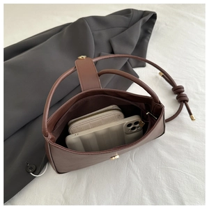 Interior view of brown leather crescent bag showing storage for wallet and phone