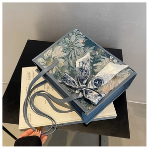 Détails d'un sac cabas jacquard floral vintage avec finitions en cuir bleu clair et foulard
