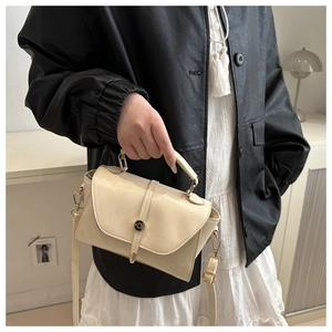 Detail of cream PU leather crossbody bag with golden hardware and adjustable strap
