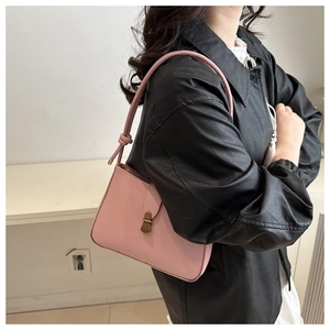 Detail of light pink leather shoulder bag with unique knotted strap and gold clasp