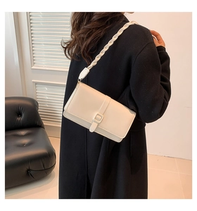 Détail d'un sac sous le bras rectangulaire blanc crème avec bandoulière épaisse tressée