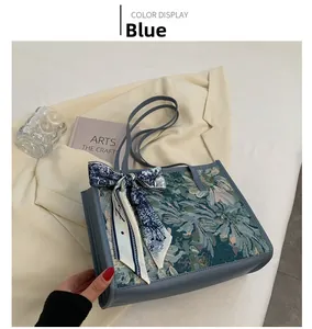 Détail du sac cabas jacquard bleu avec foulard en soie décoratif sur veste décontractée
