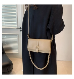 Détail du petit sac carré en cuir beige avec poignée tressée et bandoulière chic
