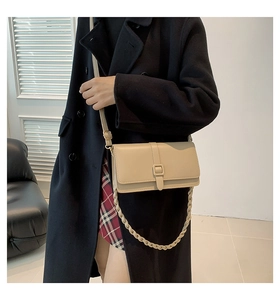 Détail du sac bandoulière beige carré avec chaîne décorative et cuir synthétique lisse