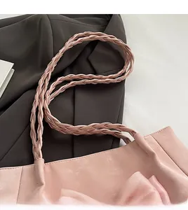 Detail der rosa Tragetasche mit bequemem gewebtem Schultergurt und Schleifenverzierung
