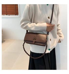 Détail du sac bandoulière marron en similicuir avec bandoulière tissée élégante