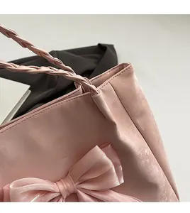 Detail der handgenähten Kanten und des geflochtenen Griffs an der rosa Totebag mit Schleife