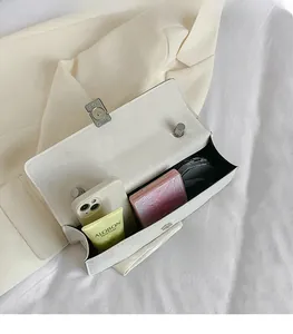 Interior view of white leather shoulder bag showing capacity for phone and cosmetics