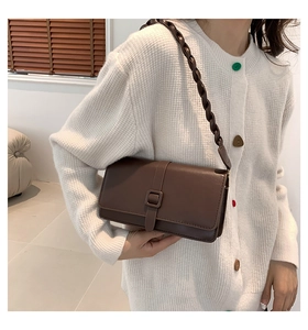 Sac à épaule marron en similicuir avec bandoulière tressée porté par un mannequin
