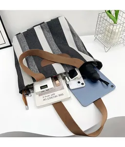 Spacious interior of striped canvas tote bag holding a tablet and daily essentials