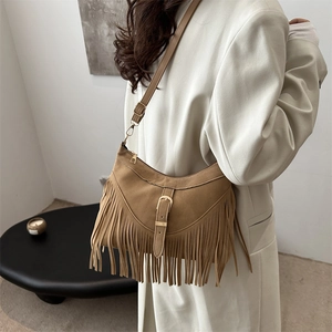 Brown suede tassel shoulder bag with vintage buckle in a bohemian tote style