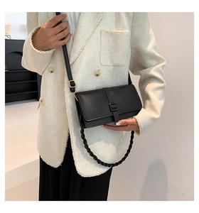 Détail du sac bandoulière rectangulaire noir avec poignée tressée et bandoulière