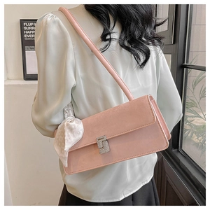 Detail of pink shoulder bag featuring a square rhinestone buckle and elegant silk scarf