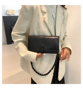 Détail d'un sac bandoulière noir minimaliste avec une bandoulière tressée chic