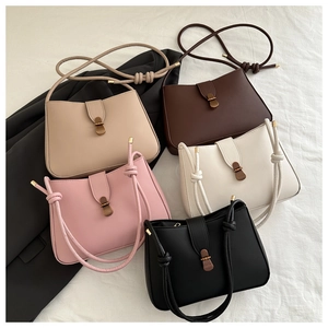 Flat lay of five faux leather crescent bags in beige, brown, pink, white, and black colors