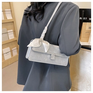 Detail of light gray square crossbody bag with rhinestone buckle and silk scarf strap
