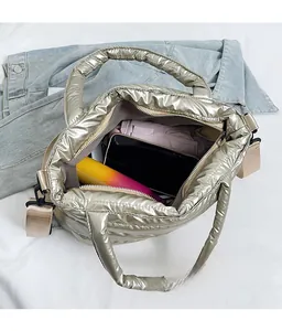Spacious interior of champagne gold quilted tote bag holding a phone, umbrella and water bottle