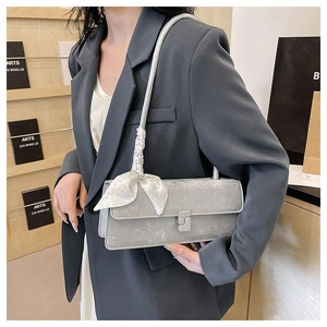 Detail of grey suede shoulder bag with silk scarf and crystal buckle on a model