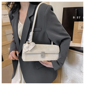 Detail of a beige textured shoulder bag with a silk scarf and sparkling S-buckle