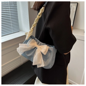 Detail of light blue cloud bag with white bow and silk scarf woven shoulder strap