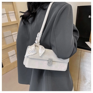 Detail of white shoulder bag with silk scarf decoration and diamond buckle