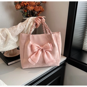 Detailaufnahme der rosa Tragetasche mit großer Schleife und geflochtenem Henkel