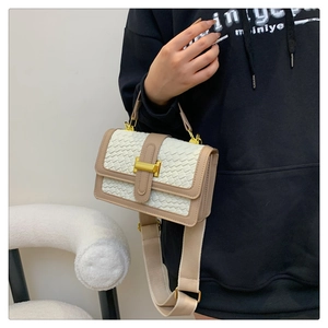 Détail du sac à main tressé blanc avec fermoir en H doré et large bandoulière textile