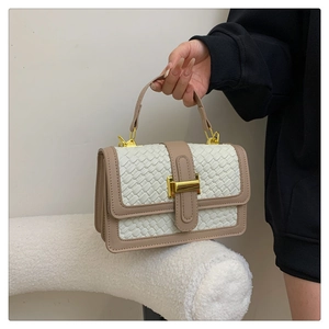 Détails de la texture en cuir tissé et boucle en métal doré d'un sac rétro chic